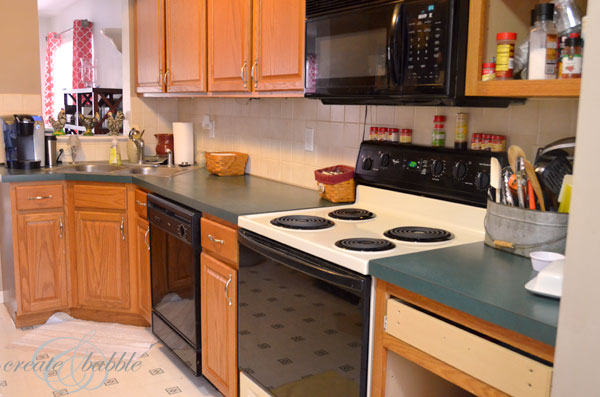 Kitchen cabinets before painting. Builder-grade cabinets in need of a facelift. How to paint builder grade cabinets white.