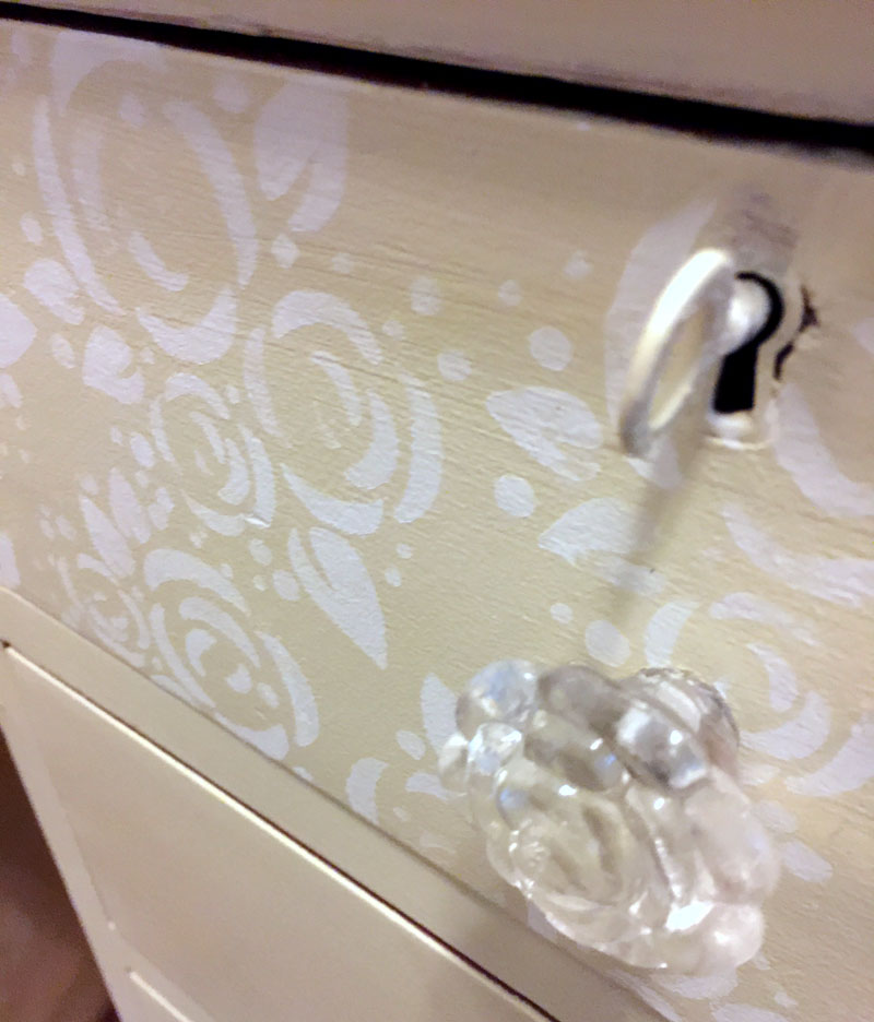 Rose stenciled drawer fronts on painted chest of drawers