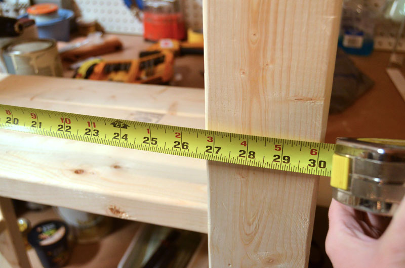 measuring-width-of-paint-storage-shelf-built-with-2x4s