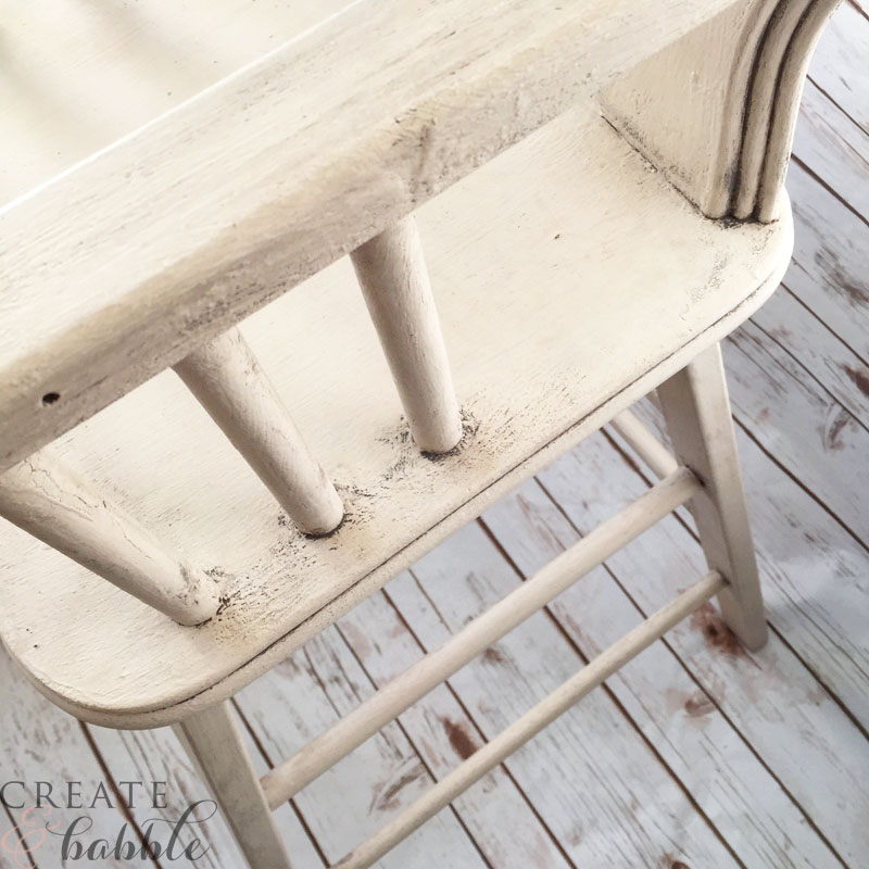 Lifting off milk paint from restored high chair gives the toscana finish