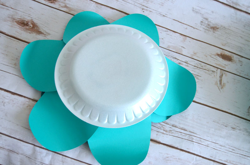 Use hot glue to attached flower to paper plate for easy hanging