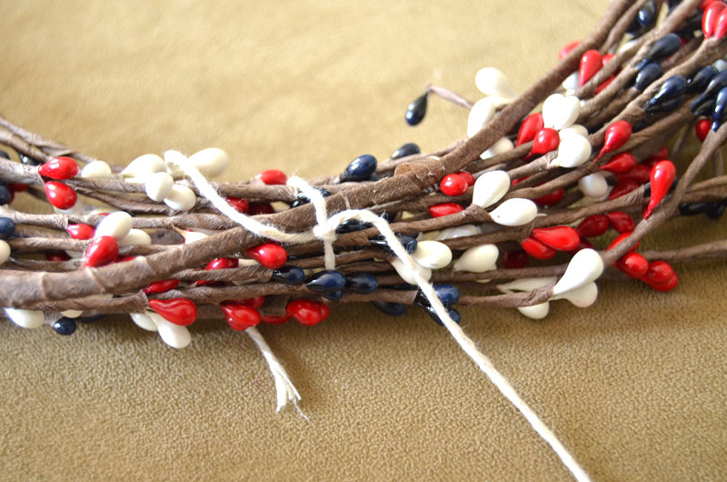 tie the twine or wire at intervals around the wreath to hold them together