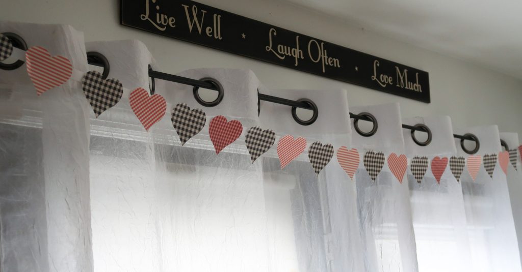 Print Then Cut Patterned Paper Heart Banner made with Cricut hanging above back door